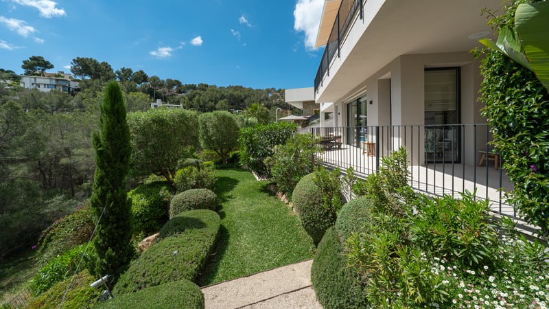 Vue extérieure d'une villa moderne avec piscine à débordement. Grandes baies vitrées, design minimaliste et jardin tropical luxuriant.