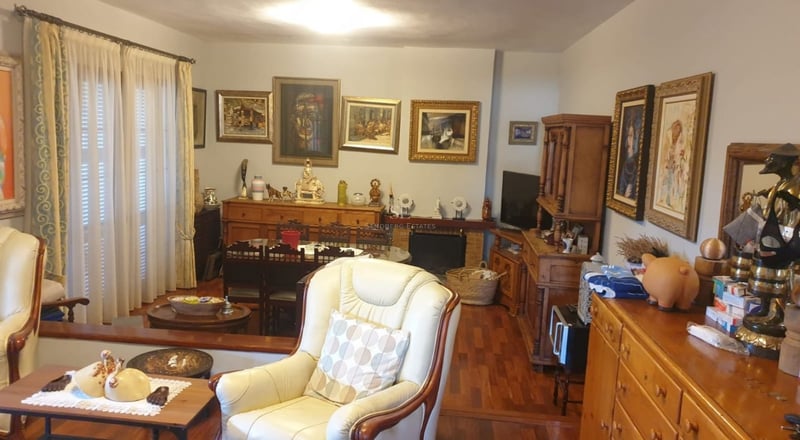 Panoramic view of a luxury villa with an infinity pool, lush garden, and modern architecture. Large terraces and picture windows.