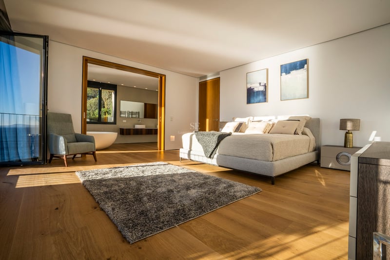 Modernes Hauptschlafzimmer mit Eichenparkett, Terrasse mit Meerblick und offenem En-Suite-Badezimmer.