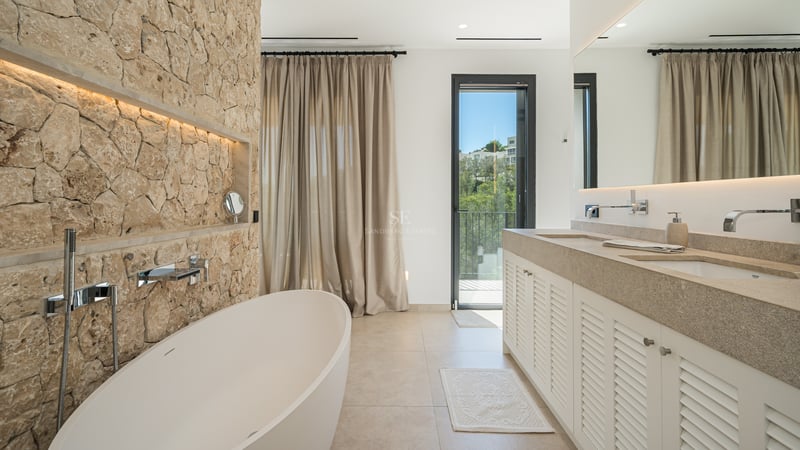 Vue extérieure d'une villa moderne avec piscine, jardin luxuriant et grandes fenêtres maximisant la lumière naturelle et les vues.