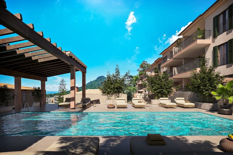 Turkos pool med solsängar under en träpergola och utsikt över berg under en klarblå himmel.