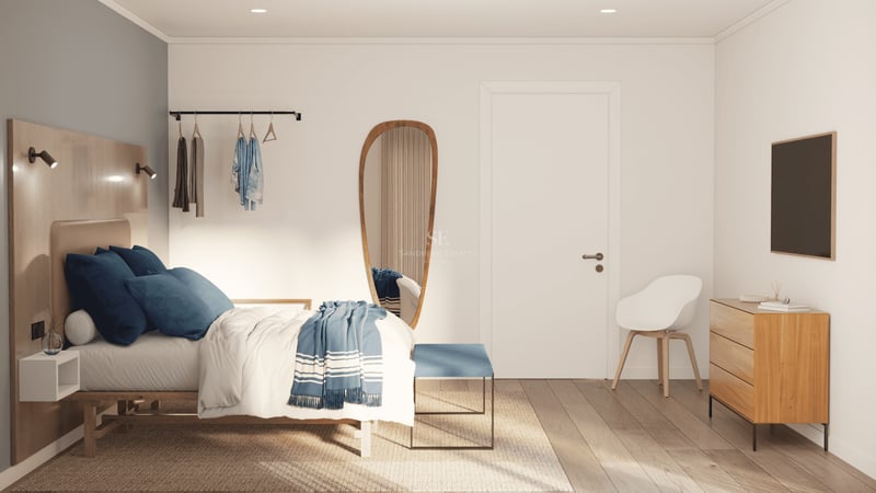 Chambre lumineuse avec lit en bois, literie bleue, miroir de forme organique et meubles en bois clair.