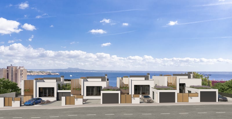 Exterior view of modern white villas with wooden accents and green roofs overlooking the Mediterranean sea.