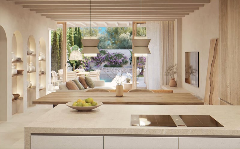 Espace ouvert avec îlot de cuisine, poutres en bois et vue sur une terrasse avec piscine et jardin.