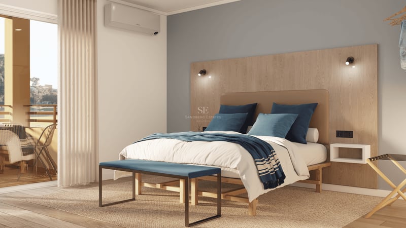 Chambre lumineuse avec grand lit, tête de lit en bois, banc bleu et accès à une terrasse ensoleillée.