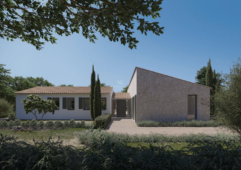 Vue extérieure d'une villa méditerranéenne de luxe avec murs en pierre, enduit blanc et volets verts.