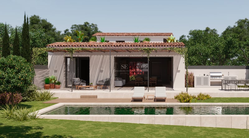 Villa blanche avec piscine rectangulaire, terrasse en pierre, cuisine extérieure et jardin verdoyant.