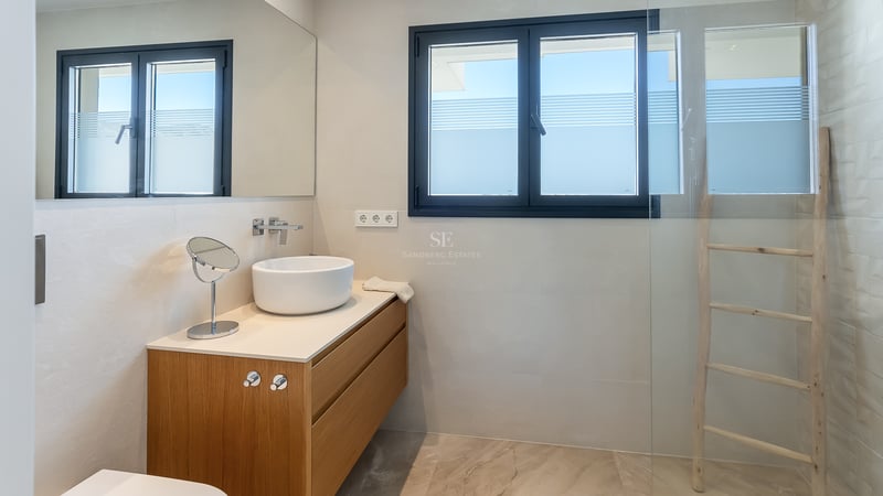 Zeitgenössisches Bad mit weißem Aufsatzwaschbecken auf Eichenunterschrank und Glasdusche.