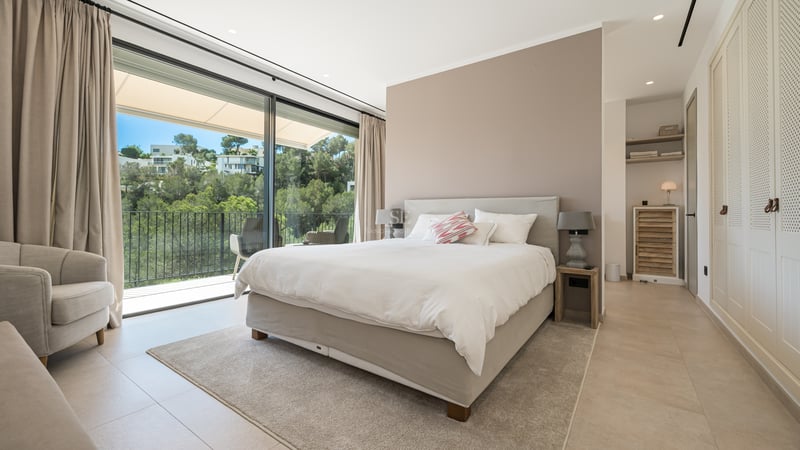 Vaste salon avec baies vitrées, cheminée moderne, canapés design, éclairage chaleureux et accès terrasse avec vue.