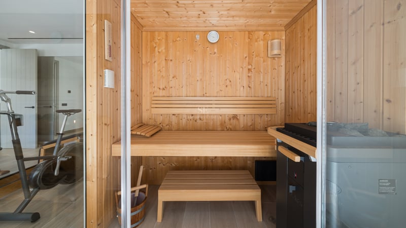 Grand balcon avec vue sur la mer. Design moderne, balustrade en verre, sol carrelé clair. Espace lumineux et élégant.