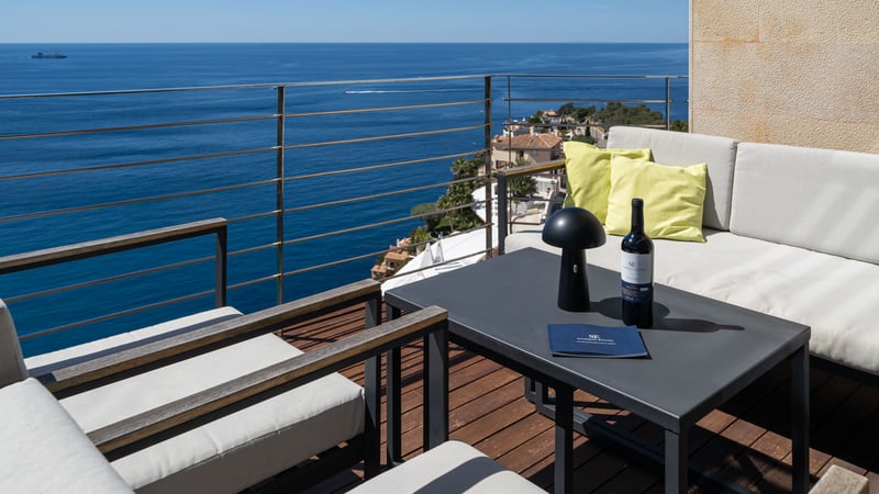 Modern terrace with lounge furniture and wooden decking overlooking the Mediterranean Sea.