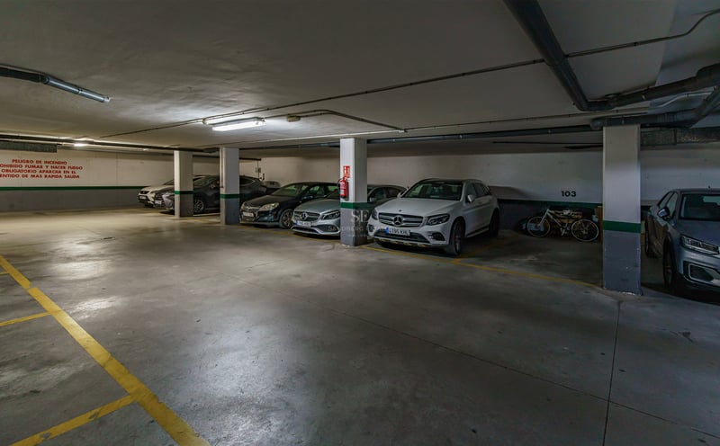 Rent underjordiskt garage med lyxbilar parkerade i numrerade rutor och gula markeringar.