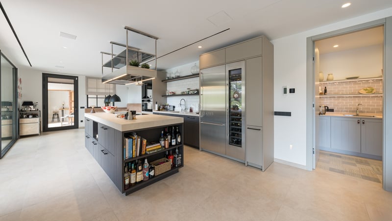 Image d'une luxueuse propriété avec piscine à débordement et vue panoramique. Design moderne avec de vastes terrasses et jardins luxuriants.