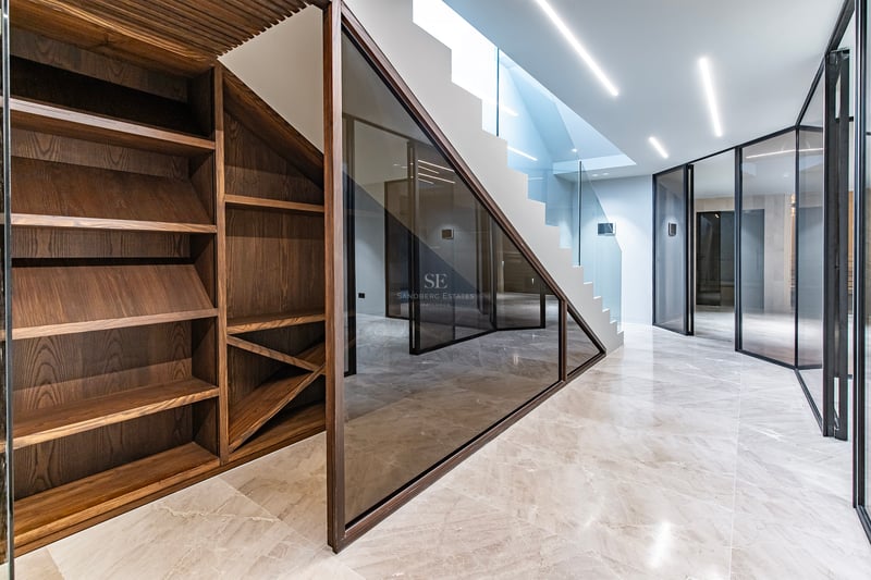Intérieur moderne avec cave à vin en noyer, sol en marbre poli, parois vitrées et escalier avec éclairage LED.