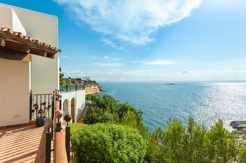 Vue extérieure d'une maison moderne avec piscine, jardin luxuriant et grandes fenêtres illuminant l'intérieur.