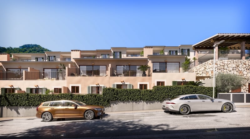 Exterior view of modern multi-level Mediterranean residences with stone walls, balconies, and cars parked on the street.
