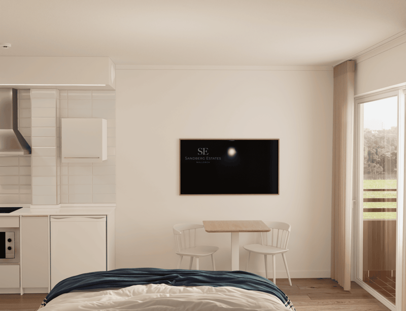 Studio lumineux avec lit, kitchenette, table à manger, télévision et porte-fenêtre.