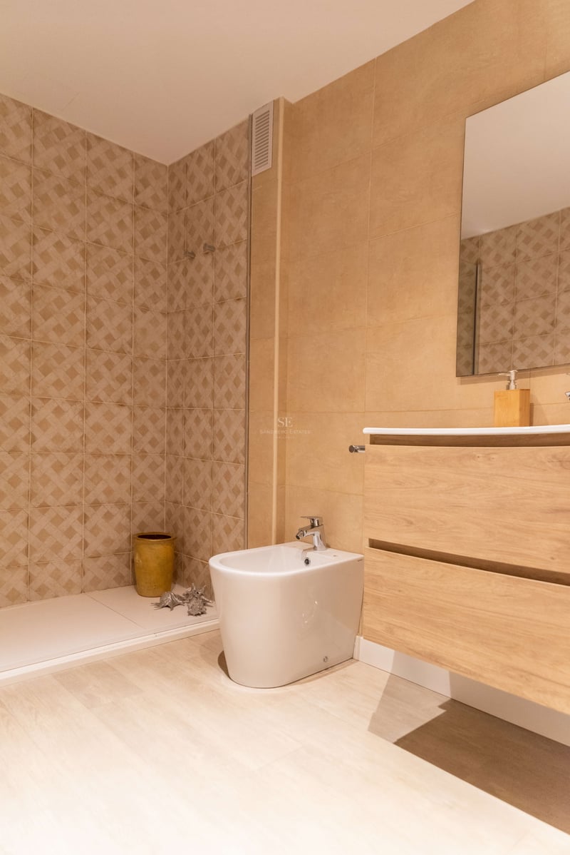 Zeitgenössisches Badezimmer mit sandfarbenen Fliesen, begehbarer Dusche, schwebendem Holzwaschtisch und weißem Bidet.