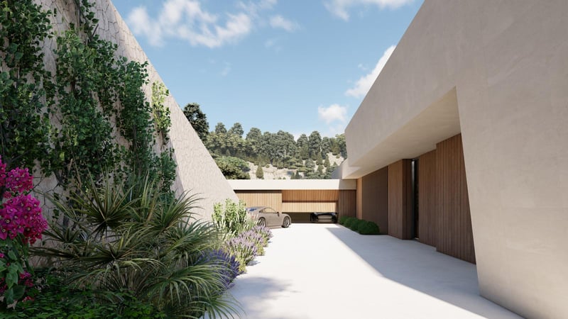Allée de villa de luxe avec murs en pierre naturelle, portes de garage en bois et bougainvilliers.